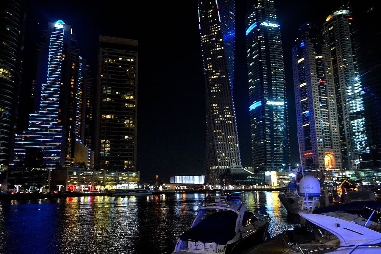 Illuminated towers and yachts at Dubai Marina at night