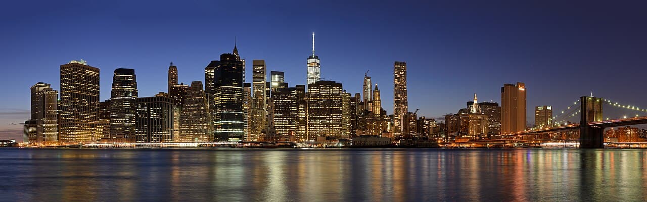 Lower Manhattan skyline and Brooklyn Bridge across the East River at dusk
