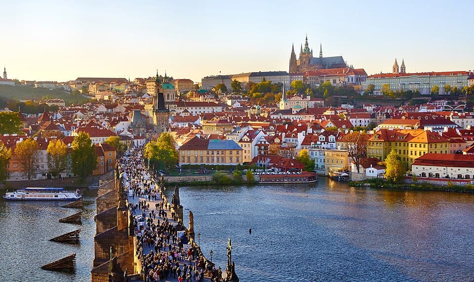 Charles Bridge across the Vltava with Prague Castle and red rooftops beyond